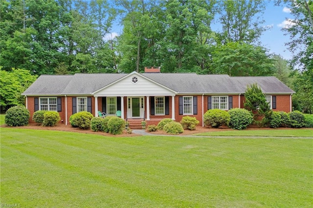 view of front of house featuring covered porch, brick siding, and a front lawn