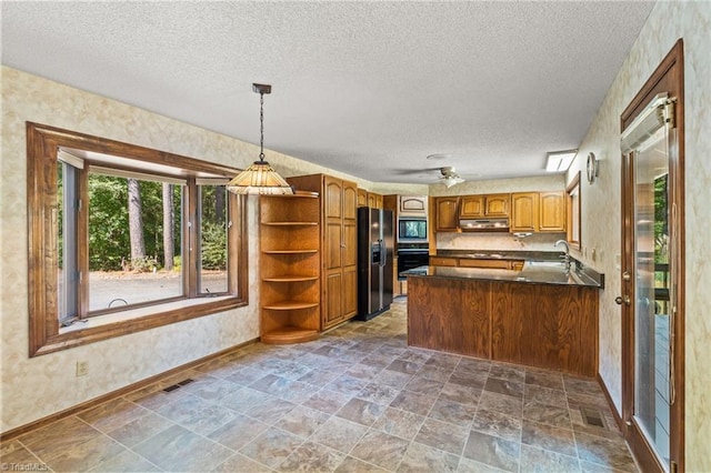 kitchen with appliances with stainless steel finishes, sink, a textured ceiling, kitchen peninsula, and ceiling fan