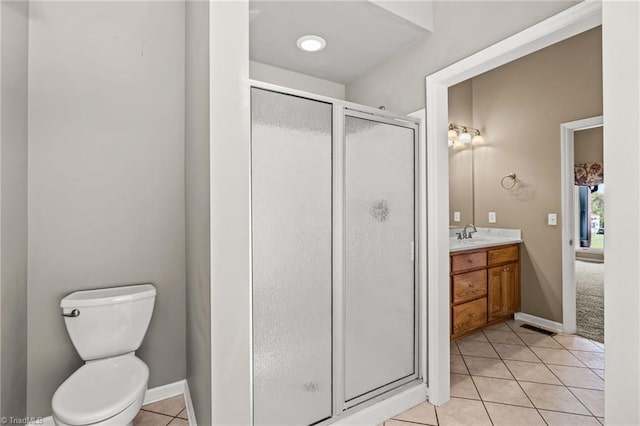 bathroom with vanity, toilet, tile patterned flooring, and a shower with door