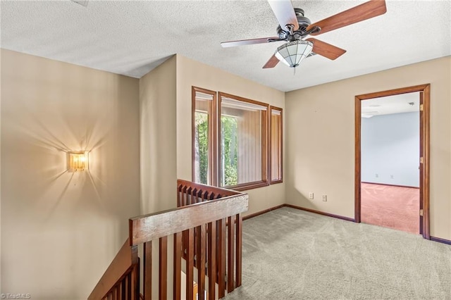 corridor featuring light carpet and a textured ceiling