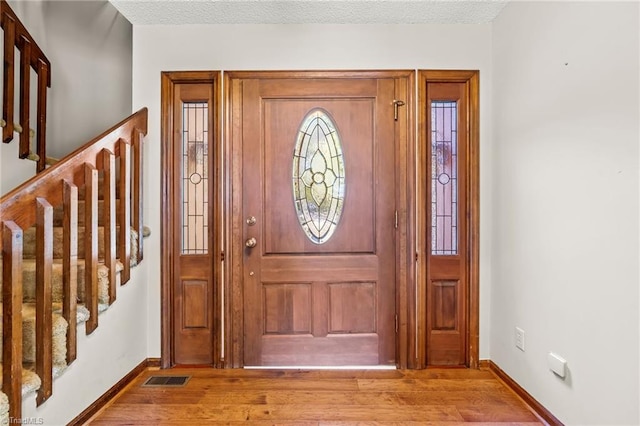 entrance foyer with light hardwood / wood-style flooring and a textured ceiling