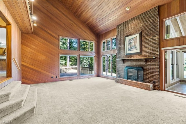 unfurnished living room featuring a wealth of natural light, wood ceiling, and high vaulted ceiling