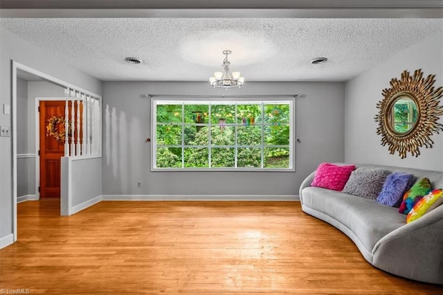4515 Gilmore Dr, Liberty, NC 27298 - living room with a chandelier, light wood finished floors, a textured ceiling, and baseboards
