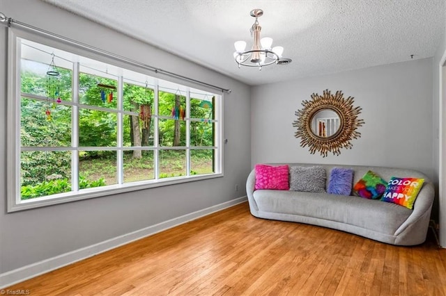 4515 Gilmore Dr, Liberty, NC 27298 - living area with a chandelier, baseboards, light wood-style floors, and a textured ceiling