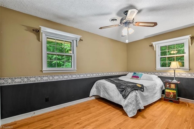 4515 Gilmore Dr, Liberty, NC 27298 - bedroom with wood finished floors, a textured ceiling, and a ceiling fan