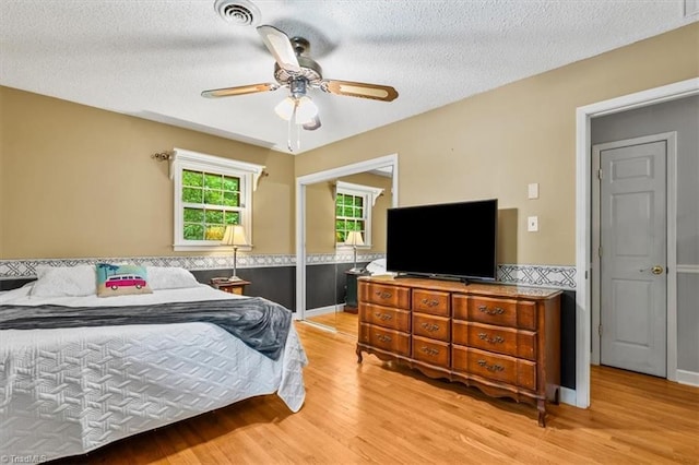 4515 Gilmore Dr, Liberty, NC 27298 - bedroom with light wood-style flooring, a textured ceiling, and a ceiling fan