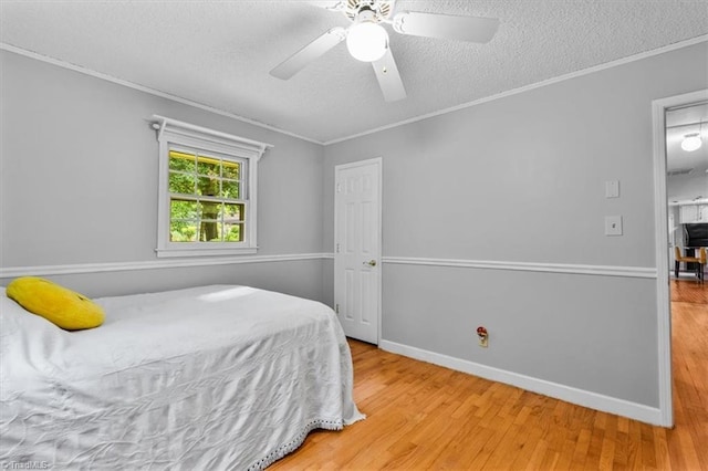 4515 Gilmore Dr, Liberty, NC 27298 - bedroom with crown molding, wood finished floors, a textured ceiling, ceiling fan, and baseboards