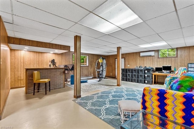 4515 Gilmore Dr, Liberty, NC 27298 - living room featuring an AC wall unit, finished concrete flooring, a drop ceiling, wood walls, and bar area