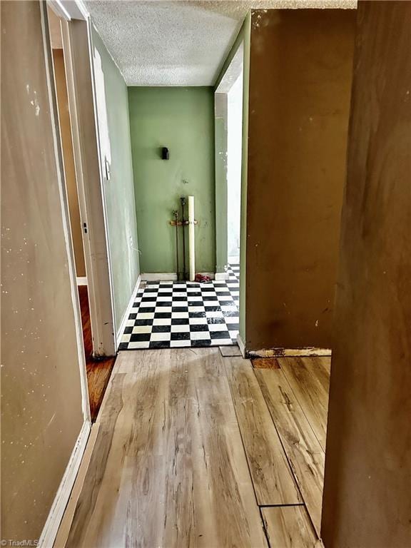 hall with hardwood / wood-style flooring and a textured ceiling