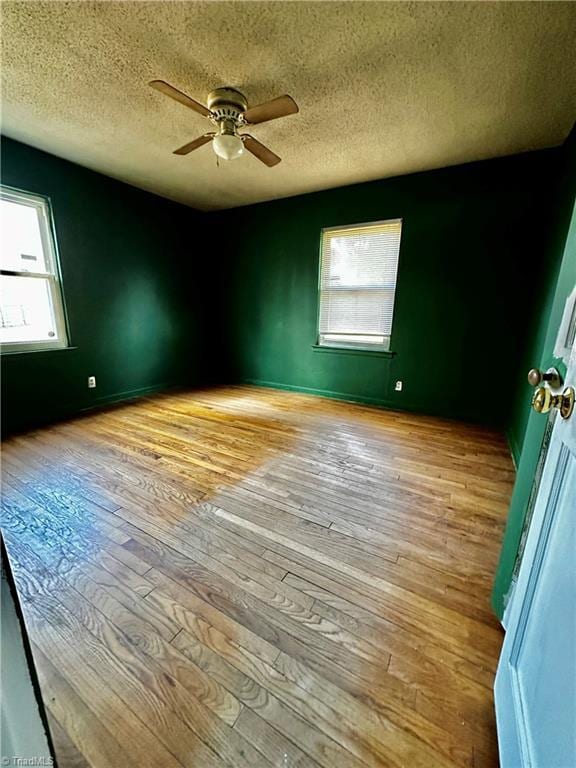 unfurnished room with ceiling fan, light hardwood / wood-style floors, and a textured ceiling