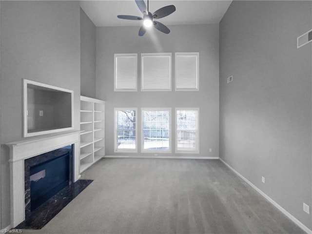 unfurnished living room featuring a towering ceiling and ceiling fan