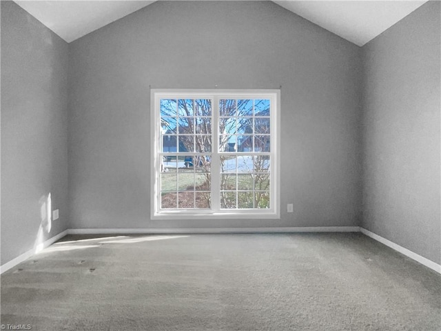 carpeted spare room with lofted ceiling