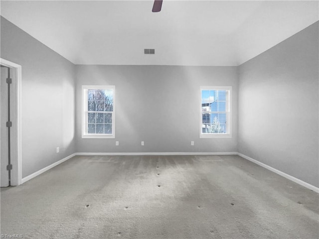 spare room featuring vaulted ceiling, ceiling fan, and carpet flooring