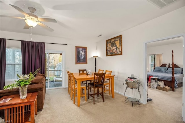 carpeted dining room with ceiling fan