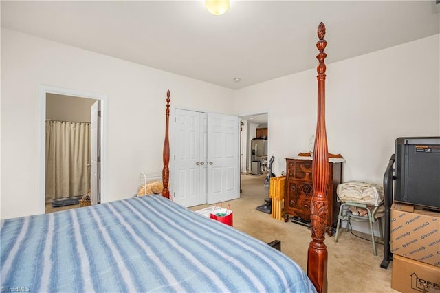 bedroom featuring light colored carpet, stainless steel refrigerator with ice dispenser, connected bathroom, and a closet