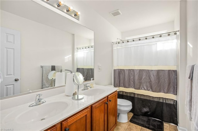 bathroom with toilet, vanity, tile patterned floors, and curtained shower