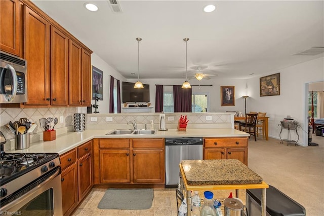 kitchen featuring sink, ceiling fan, decorative light fixtures, kitchen peninsula, and stainless steel appliances