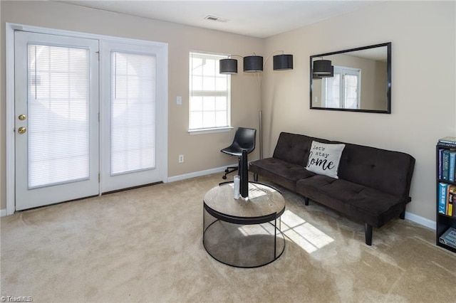 carpeted living room with visible vents and baseboards