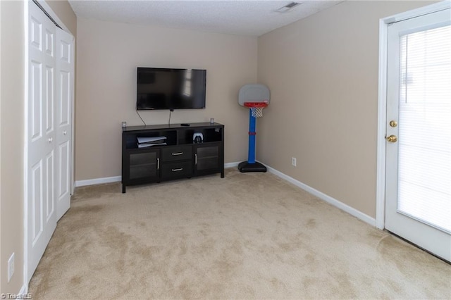 carpeted living area with a healthy amount of sunlight, visible vents, and baseboards