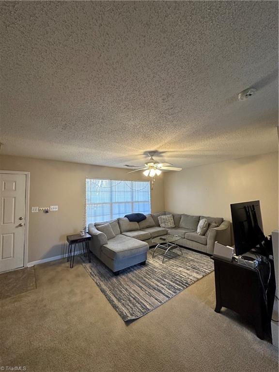 living area with baseboards, carpet floors, a textured ceiling, and ceiling fan