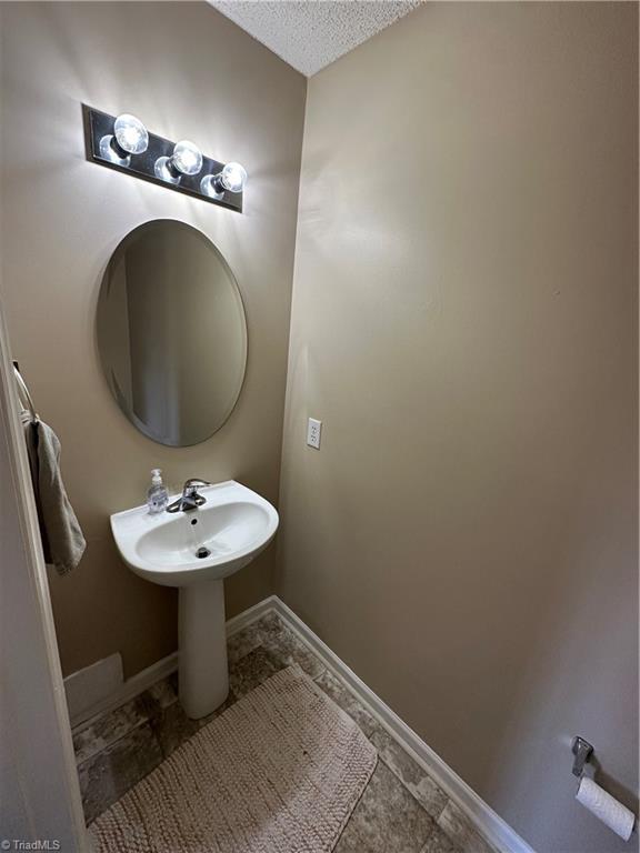 bathroom featuring baseboards and a textured ceiling