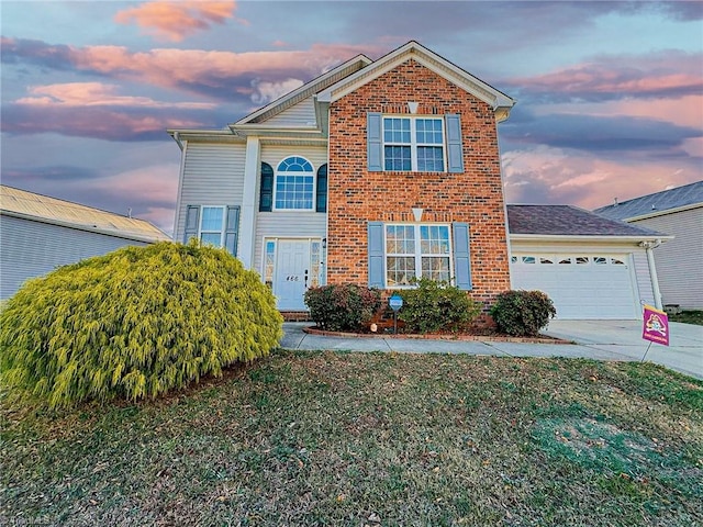 traditional home featuring a front yard, brick siding, driveway, and an attached garage