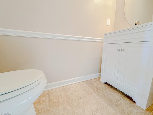 bathroom with toilet, tile patterned flooring, vanity, and baseboards