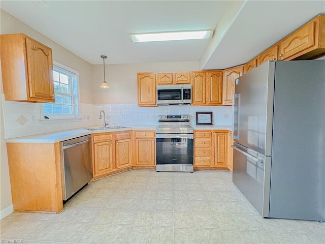 kitchen featuring stainless steel appliances, light countertops, a sink, and tasteful backsplash