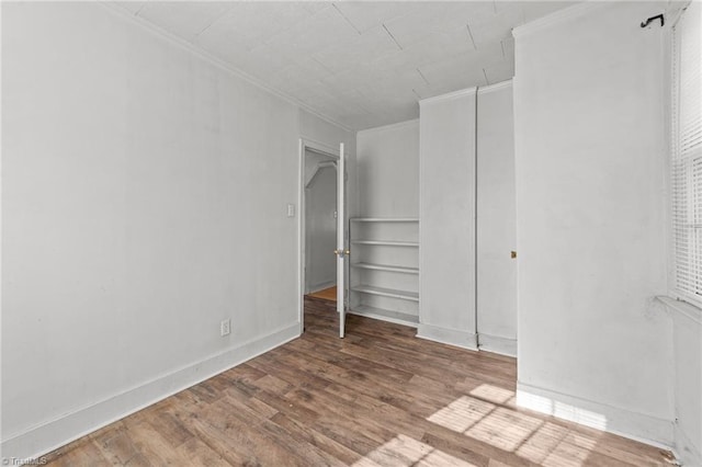 unfurnished bedroom with crown molding and wood-type flooring