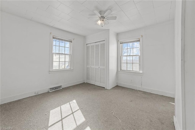 unfurnished bedroom featuring ceiling fan, light colored carpet, and a closet