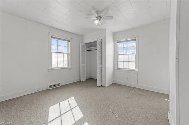 unfurnished bedroom featuring light carpet, ceiling fan, and a closet