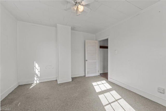 unfurnished room with ornamental molding, carpet, and ceiling fan