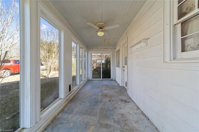 unfurnished sunroom with ceiling fan