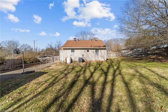 back of house featuring a carport, a yard, and central AC unit