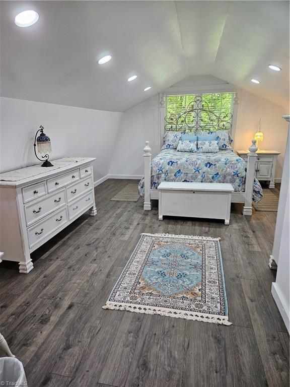 bedroom featuring dark hardwood / wood-style floors and lofted ceiling