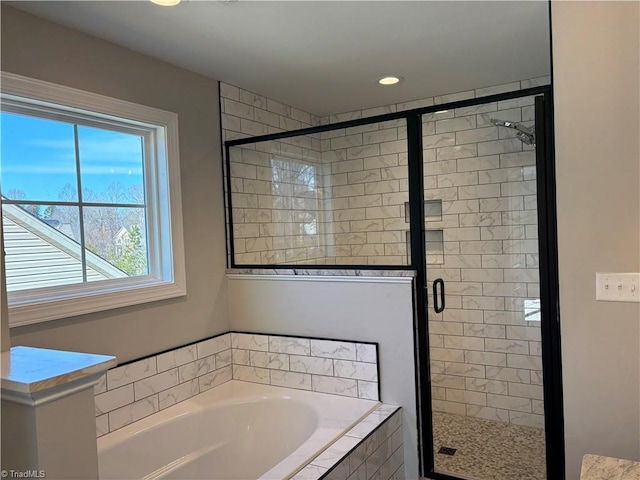 full bathroom with a shower stall and a bath