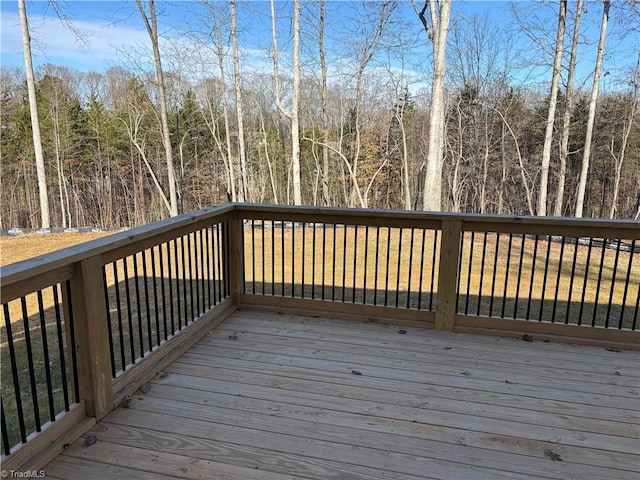 wooden terrace featuring a wooded view