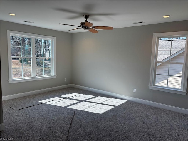 carpeted empty room with plenty of natural light, visible vents, baseboards, and ceiling fan
