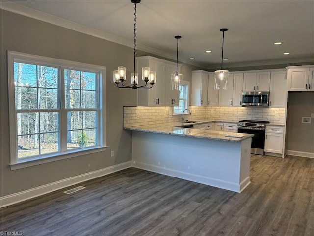 kitchen featuring stainless steel appliances, a peninsula, white cabinetry, and light stone countertops