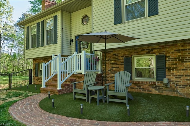 6130 Narrow Way Ln, Winston-Salem, NC 27105 - view of exterior entry featuring fence, a chimney, and brick siding