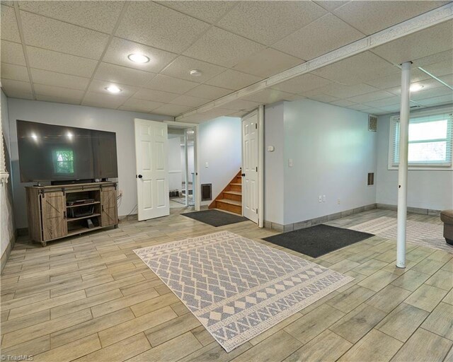 6130 Narrow Way Ln, Winston-Salem, NC 27105 - basement with light wood-style flooring, stairway, baseboards, and a paneled ceiling
