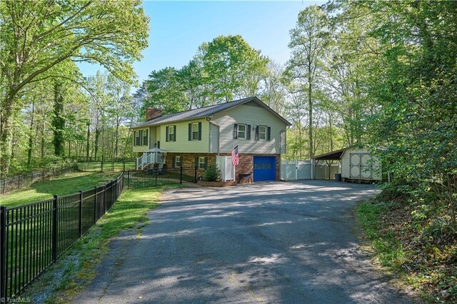 6130 Narrow Way Ln, Winston-Salem, NC 27105 - view of front of property with asphalt driveway, a chimney, a storage unit, and a garage