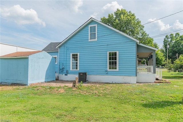 rear view of property with a yard and a shed