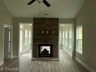 unfurnished living room featuring a large fireplace, hardwood / wood-style flooring, ceiling fan, and lofted ceiling