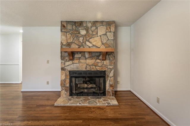 interior details featuring hardwood / wood-style floors, a stone fireplace, and a textured ceiling