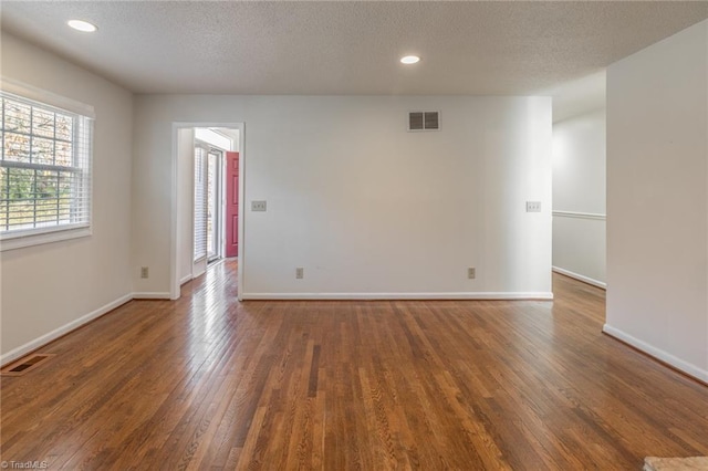 empty room featuring dark wood-type flooring and a textured ceiling