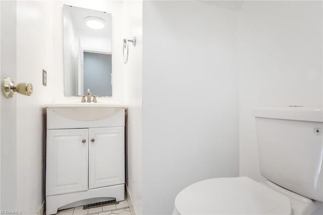 bathroom with tile patterned flooring, vanity, and toilet