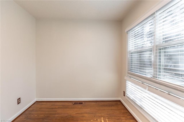 unfurnished room featuring dark hardwood / wood-style flooring