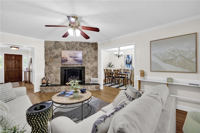living area with crown molding, ceiling fan with notable chandelier, and wood finished floors