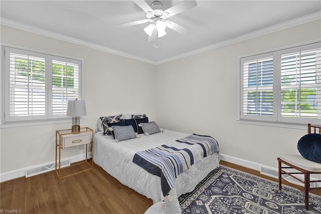 bedroom featuring crown molding, baseboards, visible vents, and wood finished floors